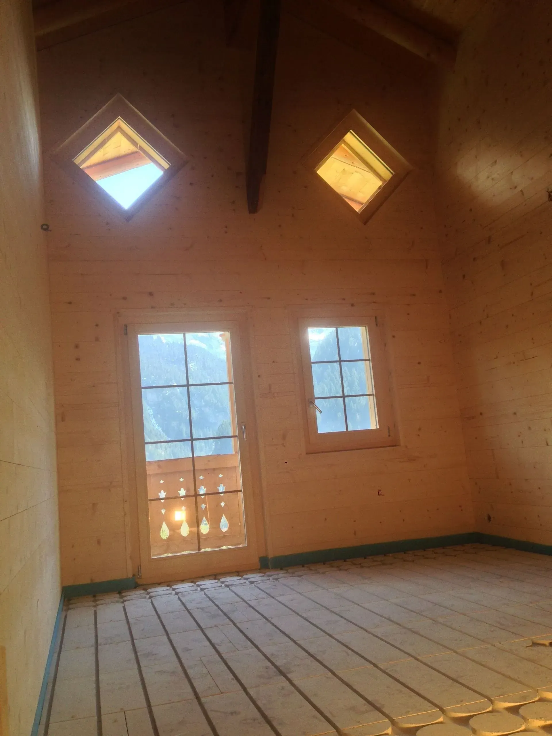 Une pièce vide avec deux fenêtres et un balcon