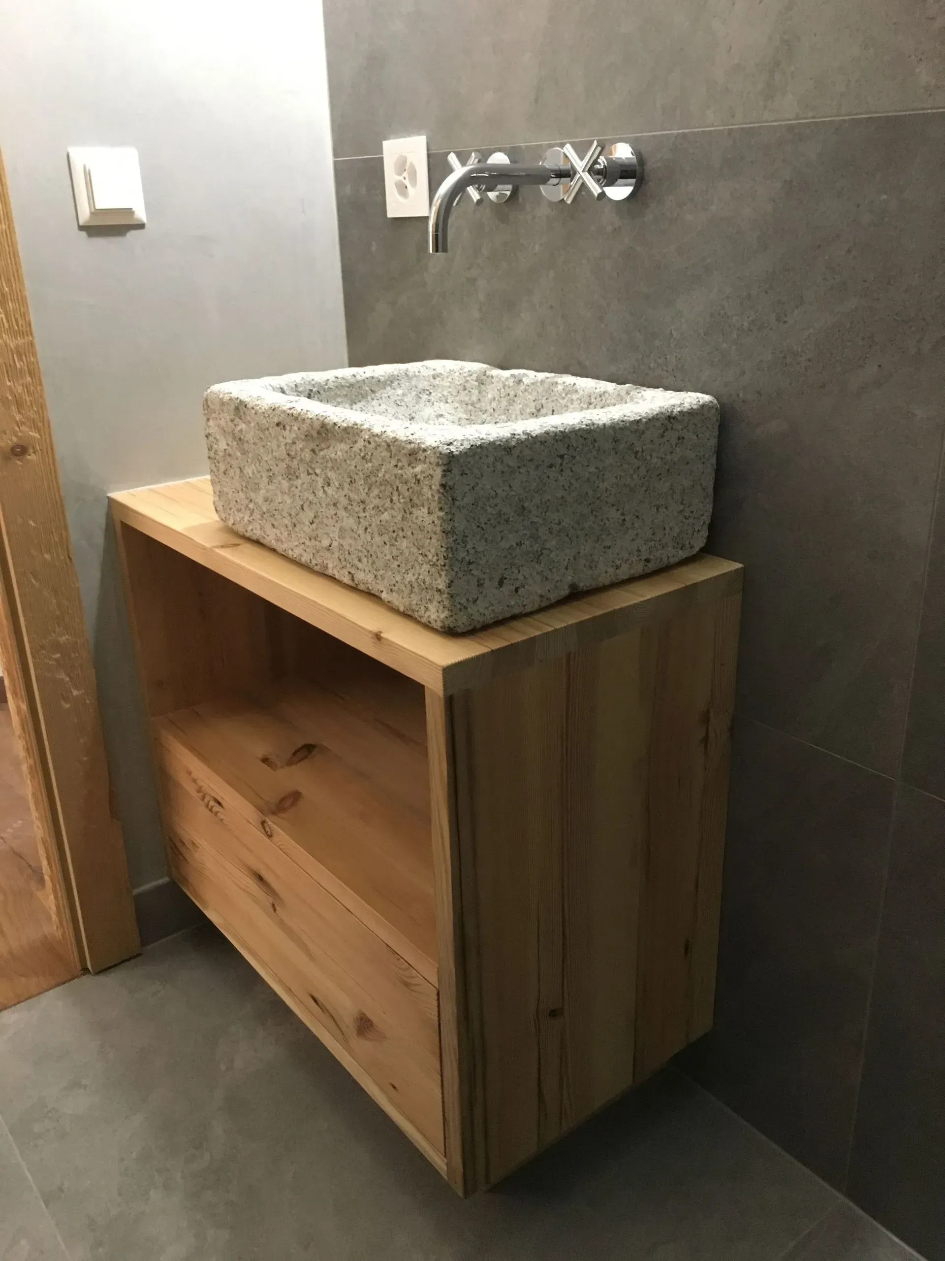 Un lavabo de salle de bain est posé sur un meuble en bois.