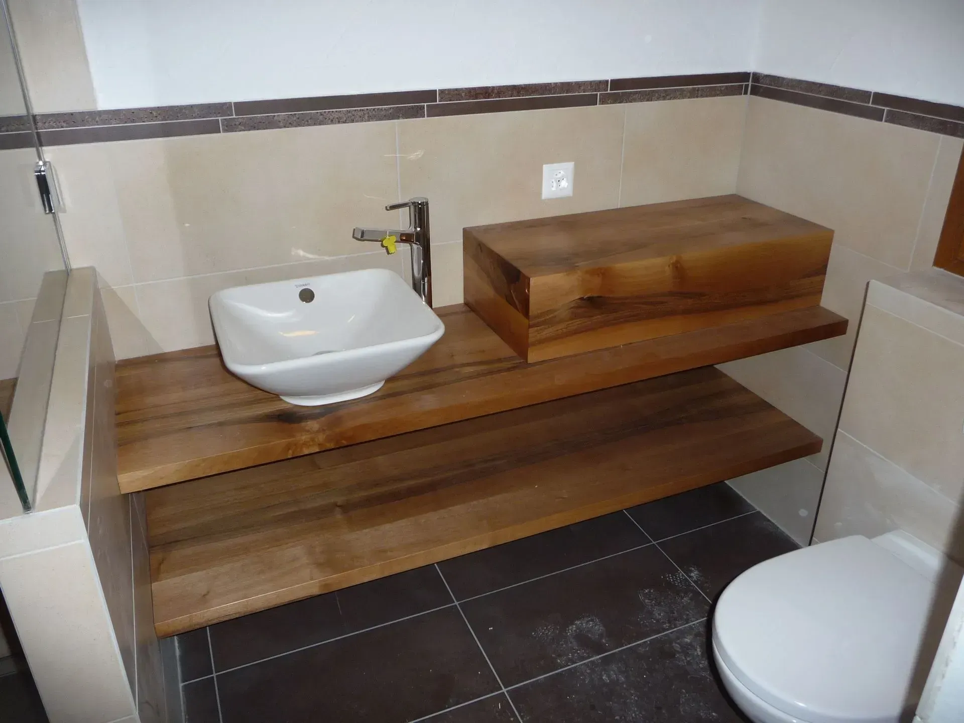Une salle de bain avec un lavabo et des toilettes sur une étagère en bois