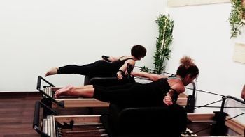 Un grupo de mujeres está haciendo pilates en una máquina de pilates.