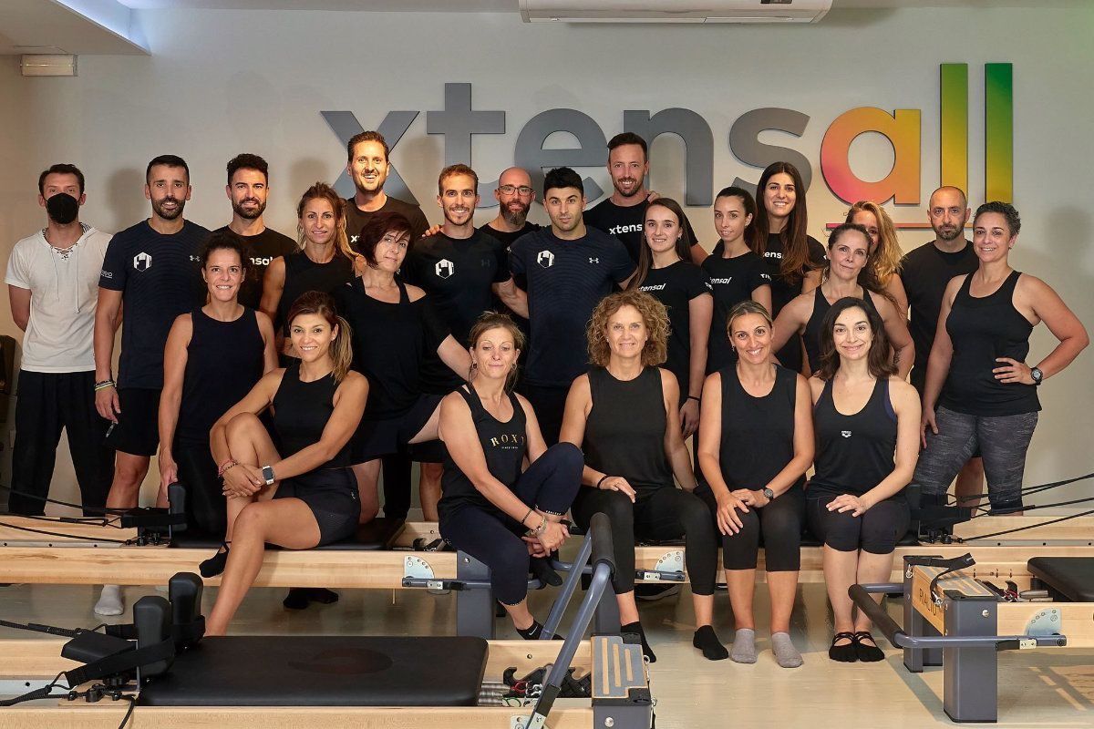 Un grupo de personas posa para una fotografía en un gimnasio.