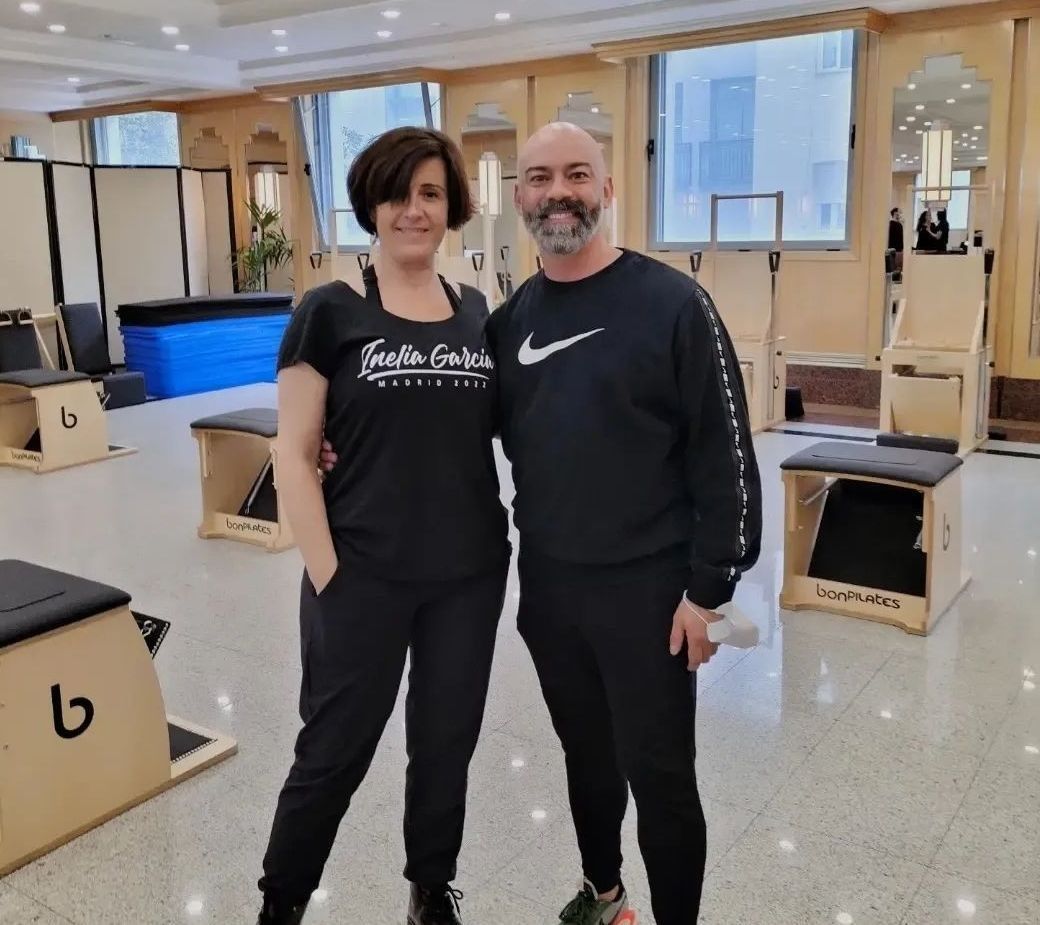 Un hombre y una mujer posan para una foto en un gimnasio.