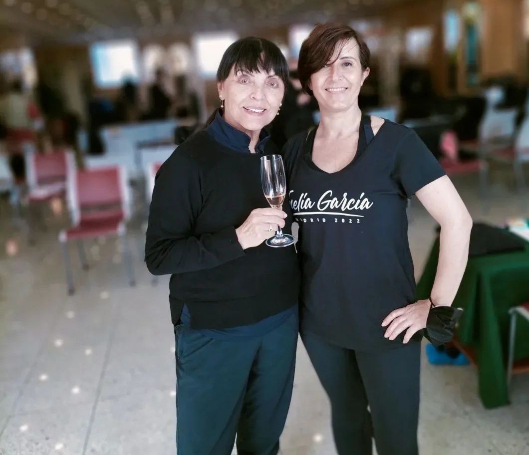 Dos mujeres paradas una al lado de la otra, una de ellas con una camiseta que dice