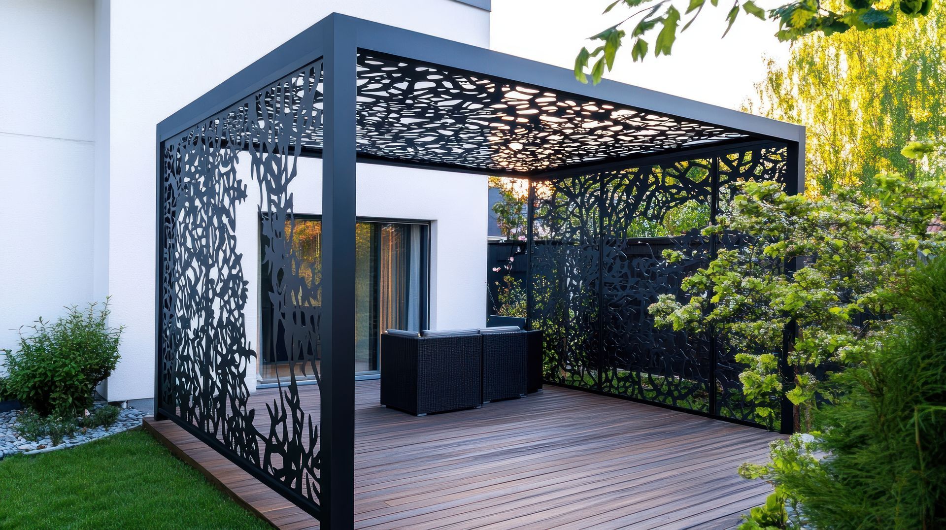 Patio moderne avec une pergola décorative sombre, une terrasse en bois et des portes coulissantes en verre jouxtant une maison blanche.