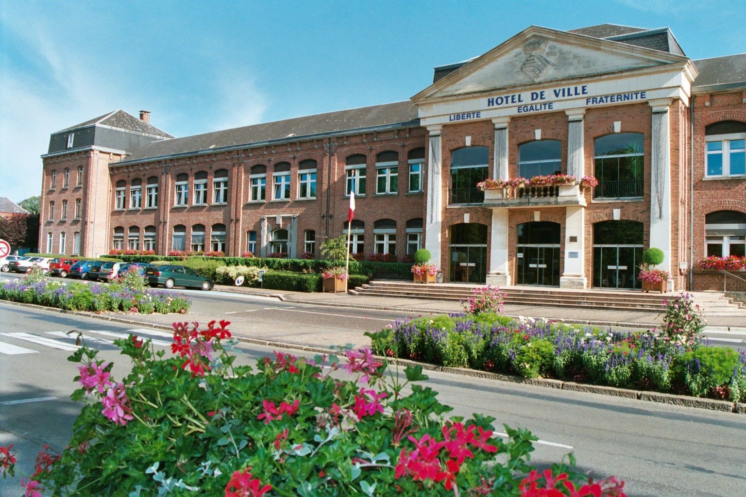 Un hôtel de ville avec des parterres de fleurs