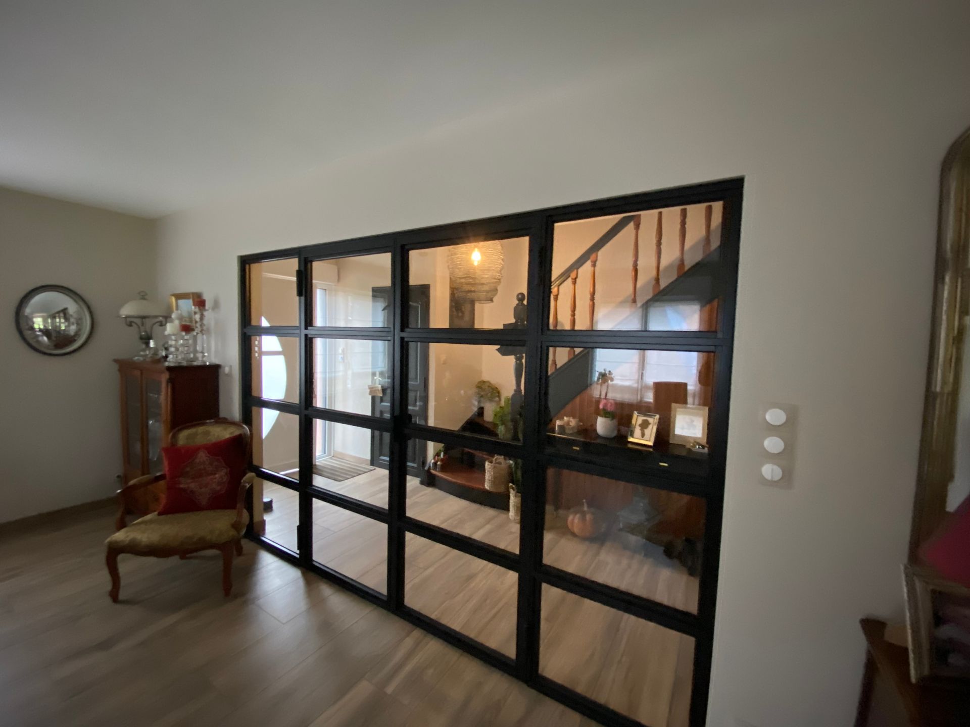Plafond d'atrium moderne en verre avec une verrière circulaire et des panneaux orange chaud en dessous
