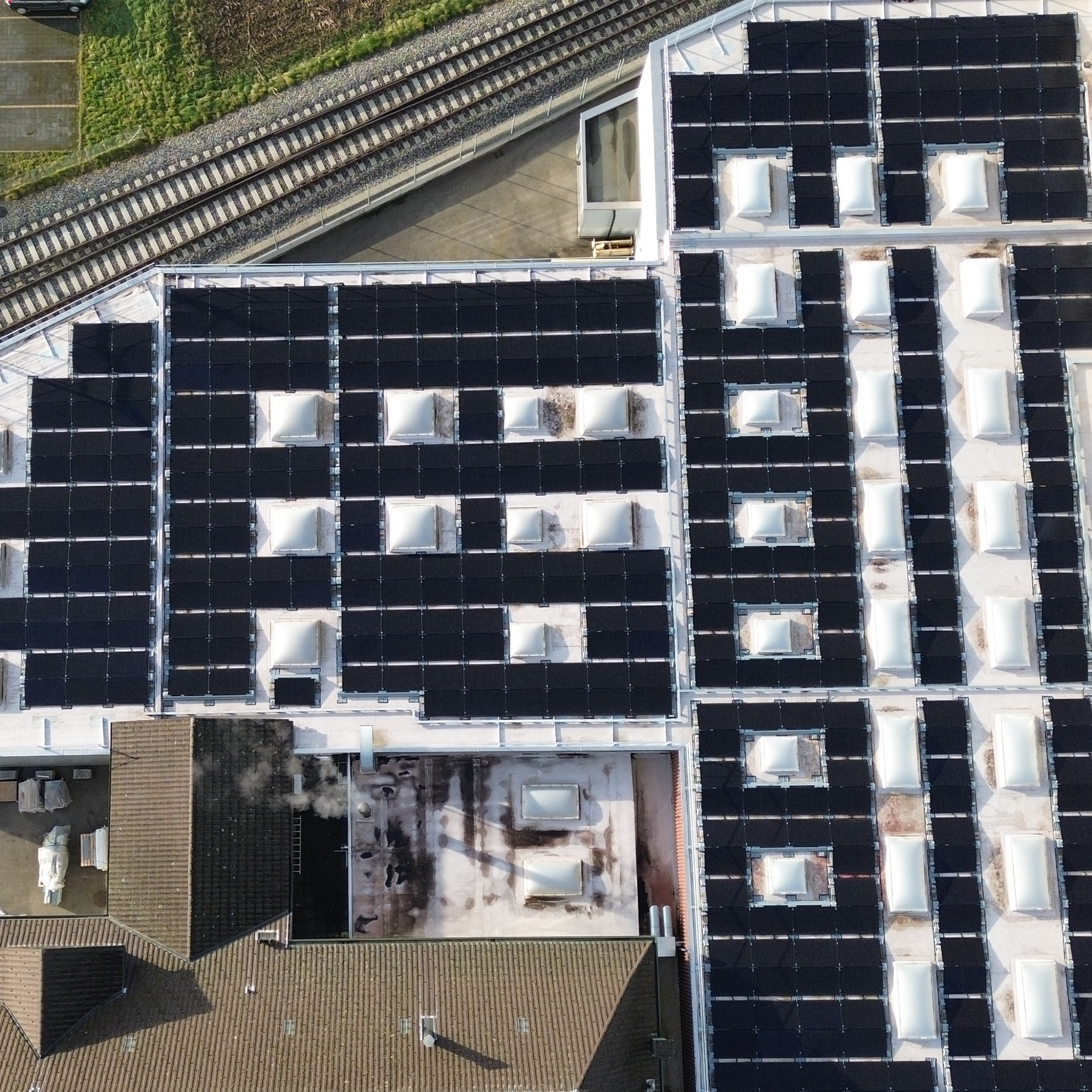 Eine Luftaufnahme eines Gebäudes mit Solarmodulen auf dem Dach