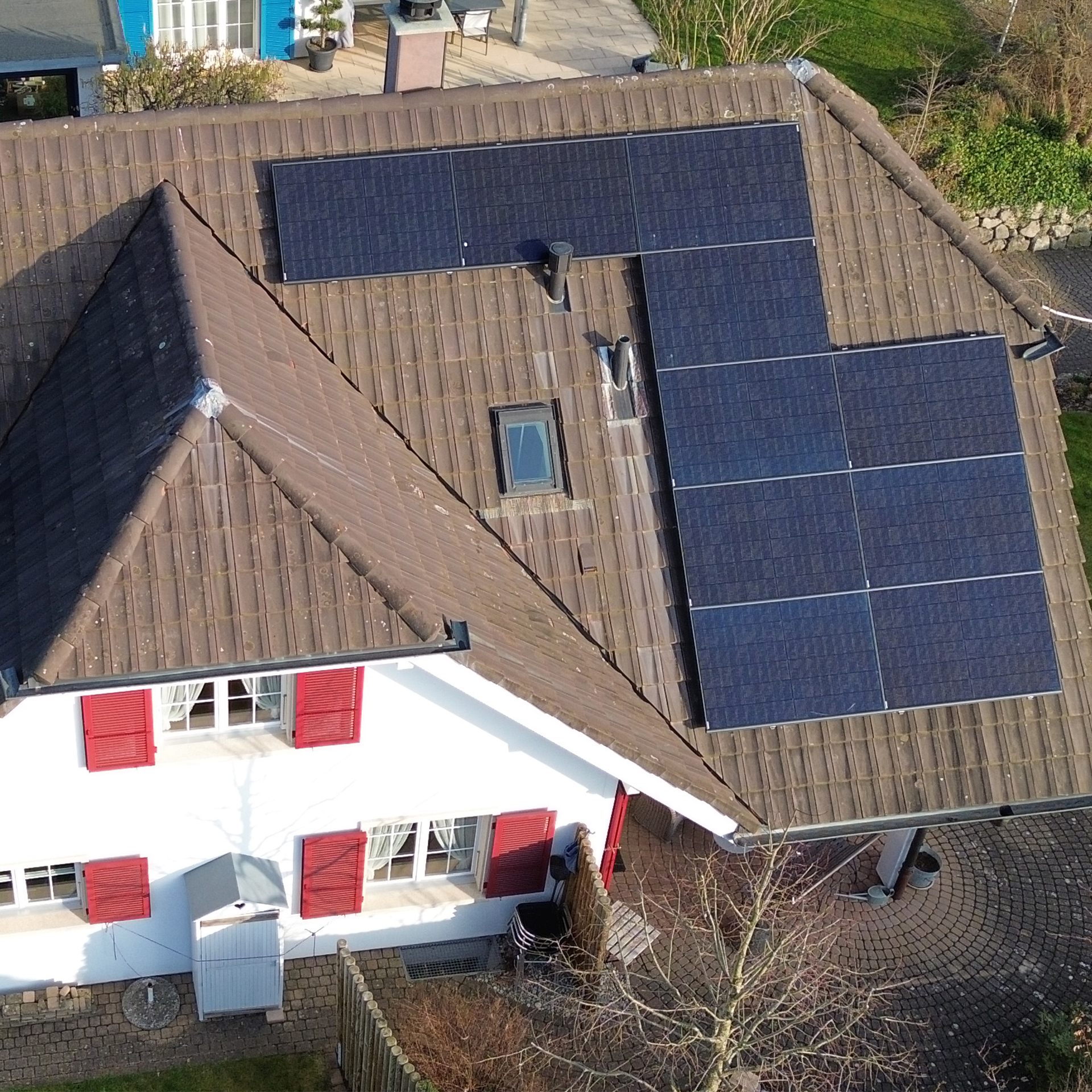 Eine Luftaufnahme eines Hauses mit Solarmodulen auf dem Dach