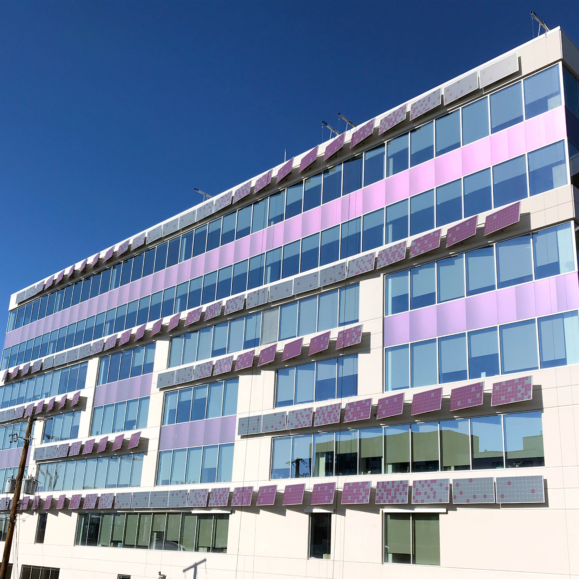 Ein großes Gebäude mit vielen Fenstern und einem blauen Himmel im Hintergrund