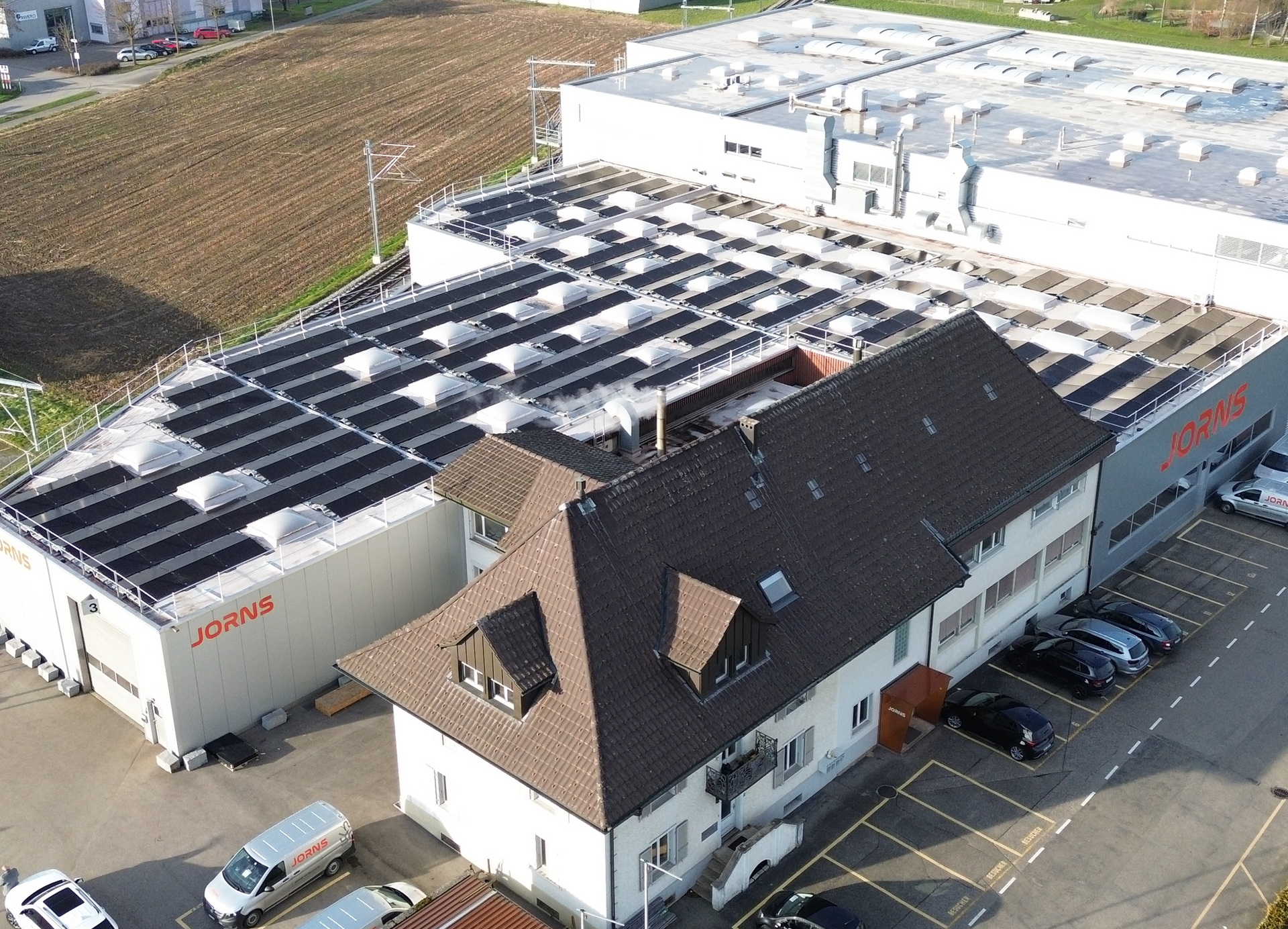 Eine Luftaufnahme eines Gebäudes mit Solarmodulen auf dem Dach