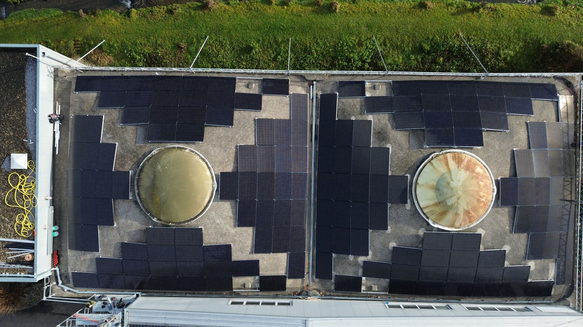 Eine Luftaufnahme eines Gebäudes mit Solarmodulen auf dem Dach