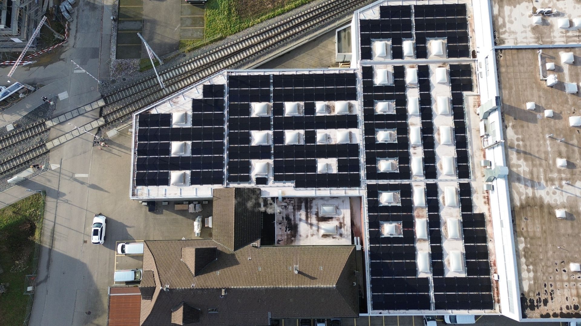 Eine Luftaufnahme eines Gebäudes mit Solarmodulen auf dem Dach