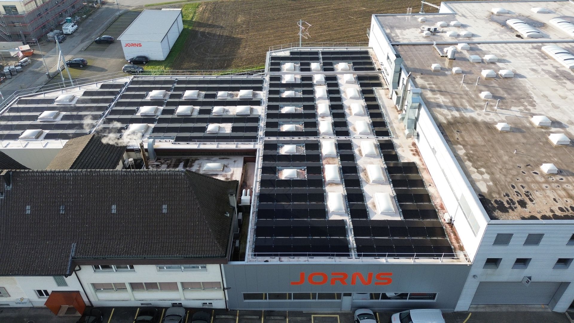 Eine Luftaufnahme eines Industriegebäude mit Solarmodulen auf dem Dach