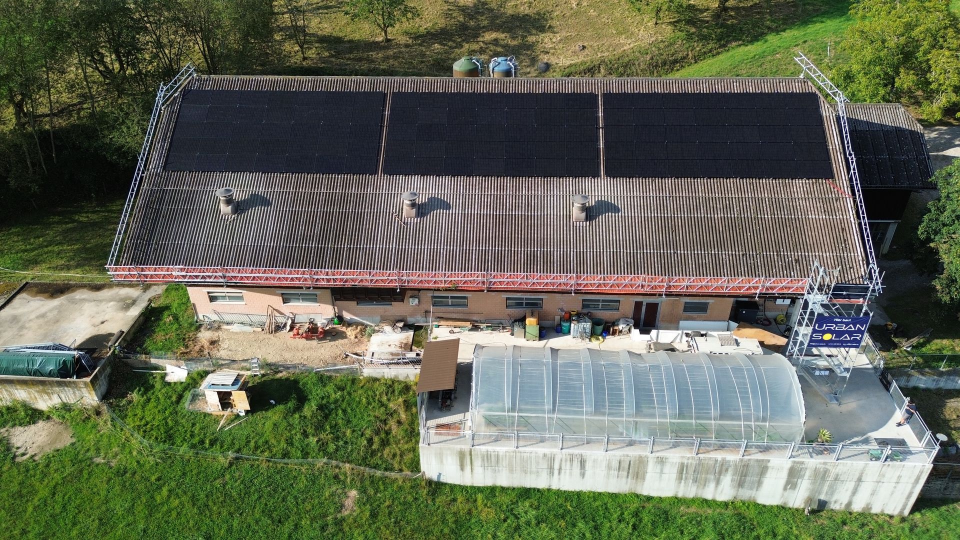 Eine Luftaufnahme eines Gebäudes mit Solarmodulen auf dem Dach