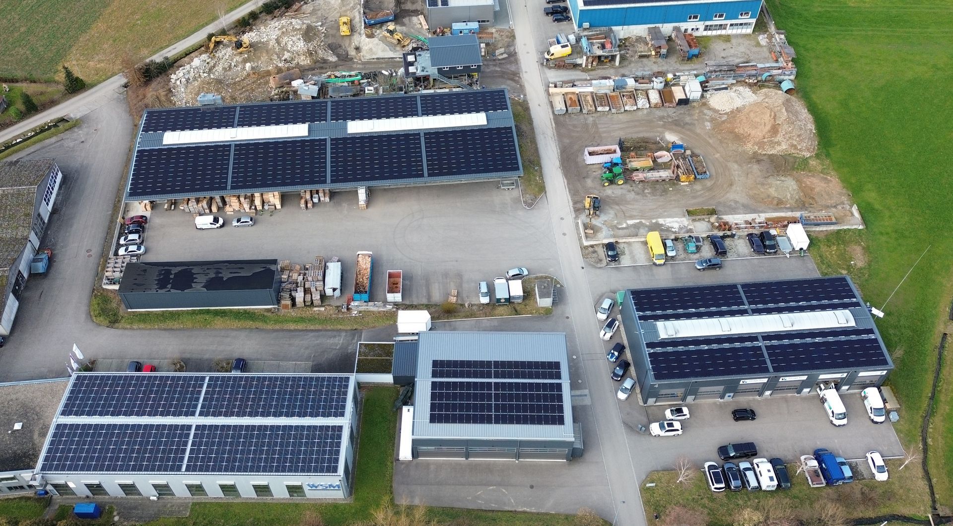 Eine Luftaufnahme eines Gebäudes mit Solarmodulen auf dem Dach