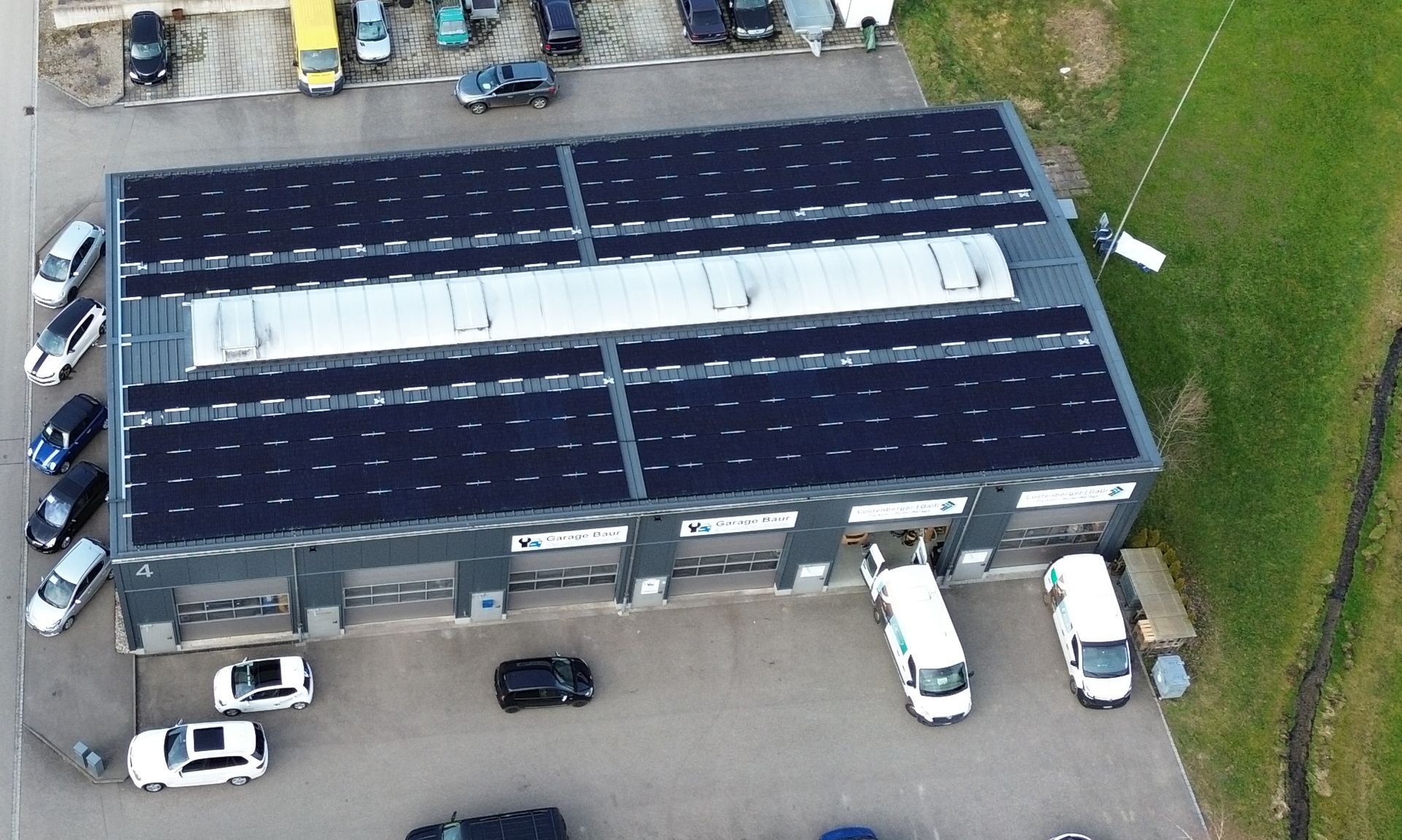 Eine Luftaufnahme eines Gebäudes mit Solarmodulen auf dem Dach