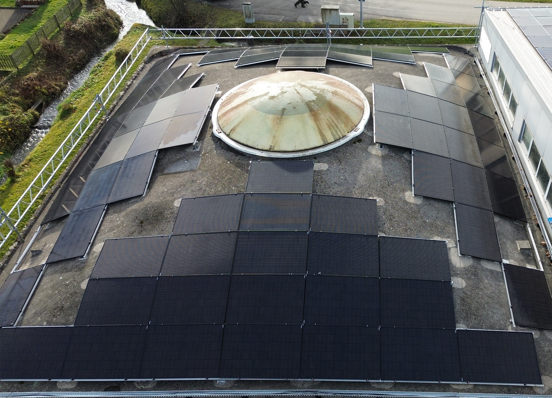 Eine Luftaufnahme eines Gebäudes mit Solarmodulen auf dem Dach