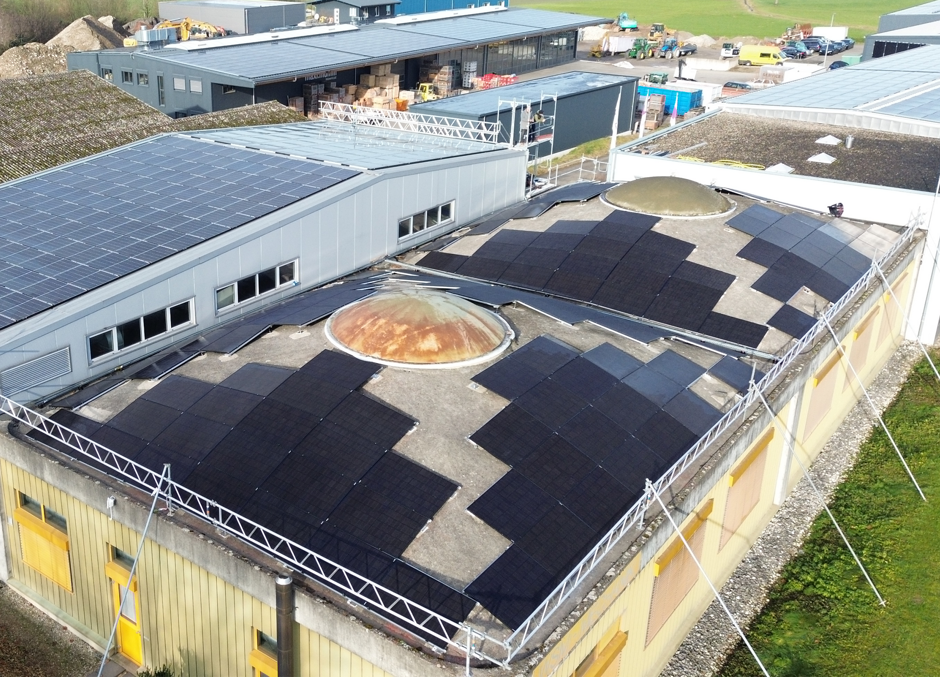 Eine Luftaufnahme eines Gebäudes mit Solarmodulen auf dem Dach.