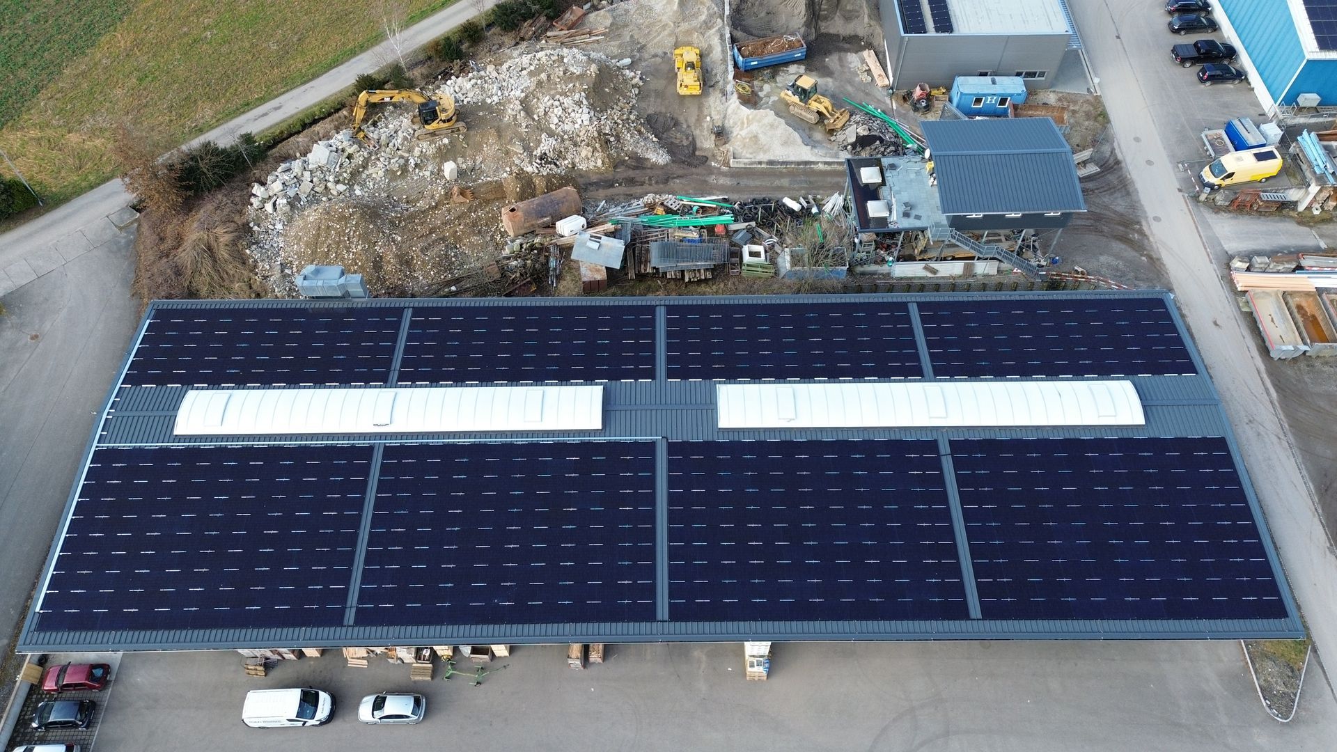 Eine Luftaufnahme eines Gebäudes mit Solarmodulen auf dem Dach