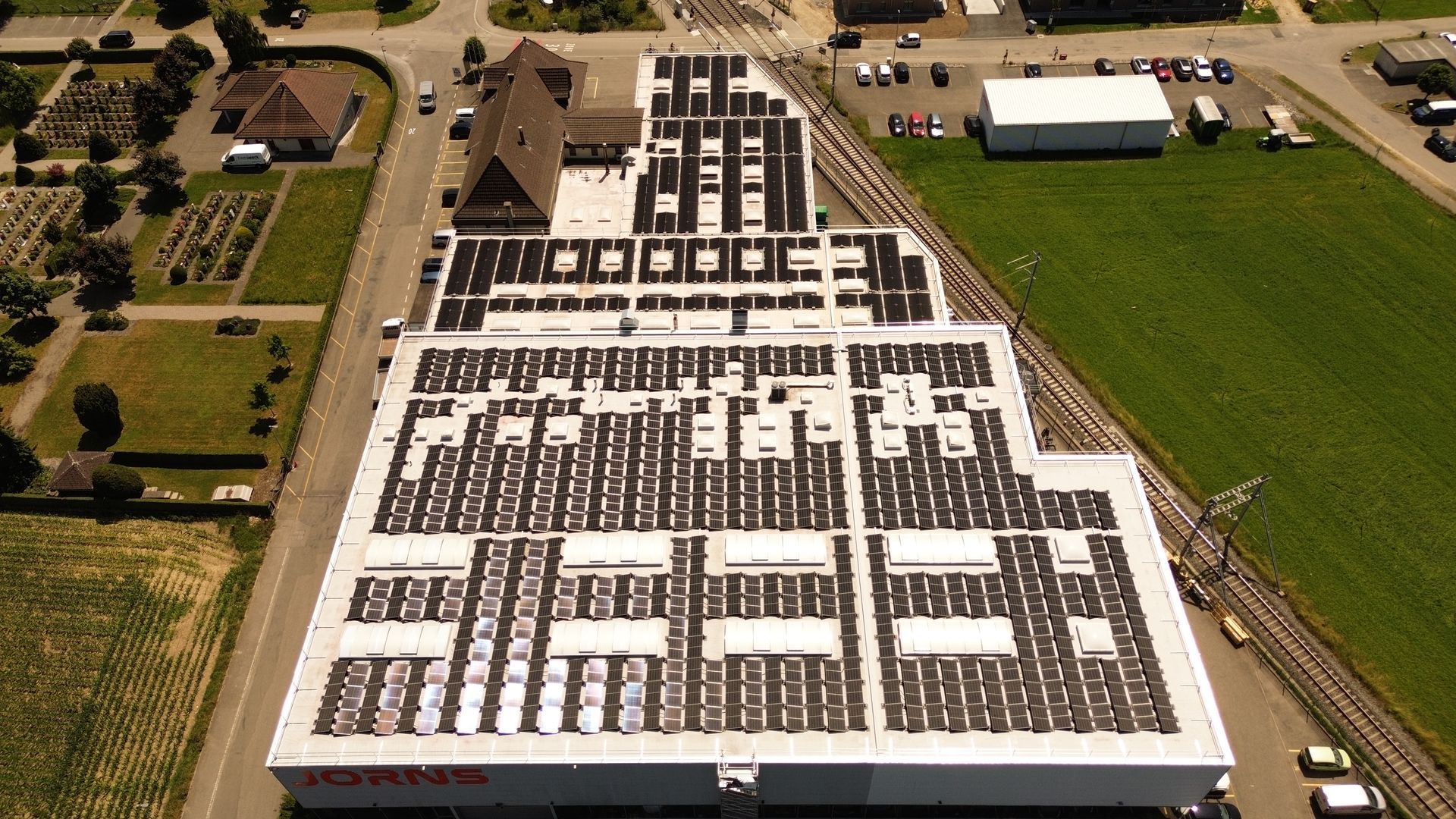 Eine Luftaufnahme eines Industriegebäude mit Solarmodulen auf dem Dach