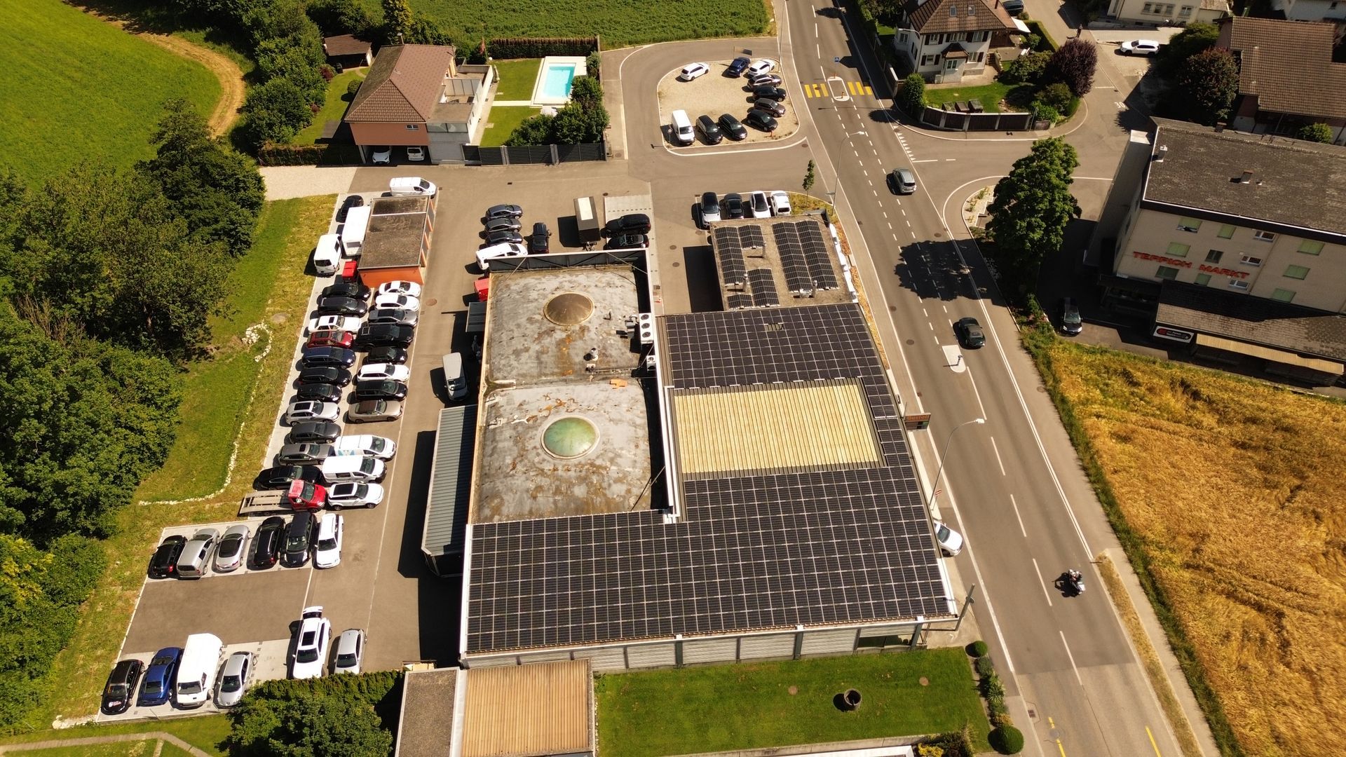 Eine Luftaufnahme eines Industriegebäude mit Solarmodulen auf dem Dach