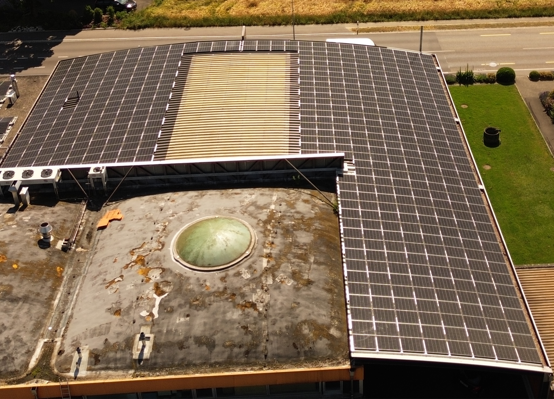 Eine Luftaufnahme eines Gebäudes mit Solarmodulen auf dem Dach