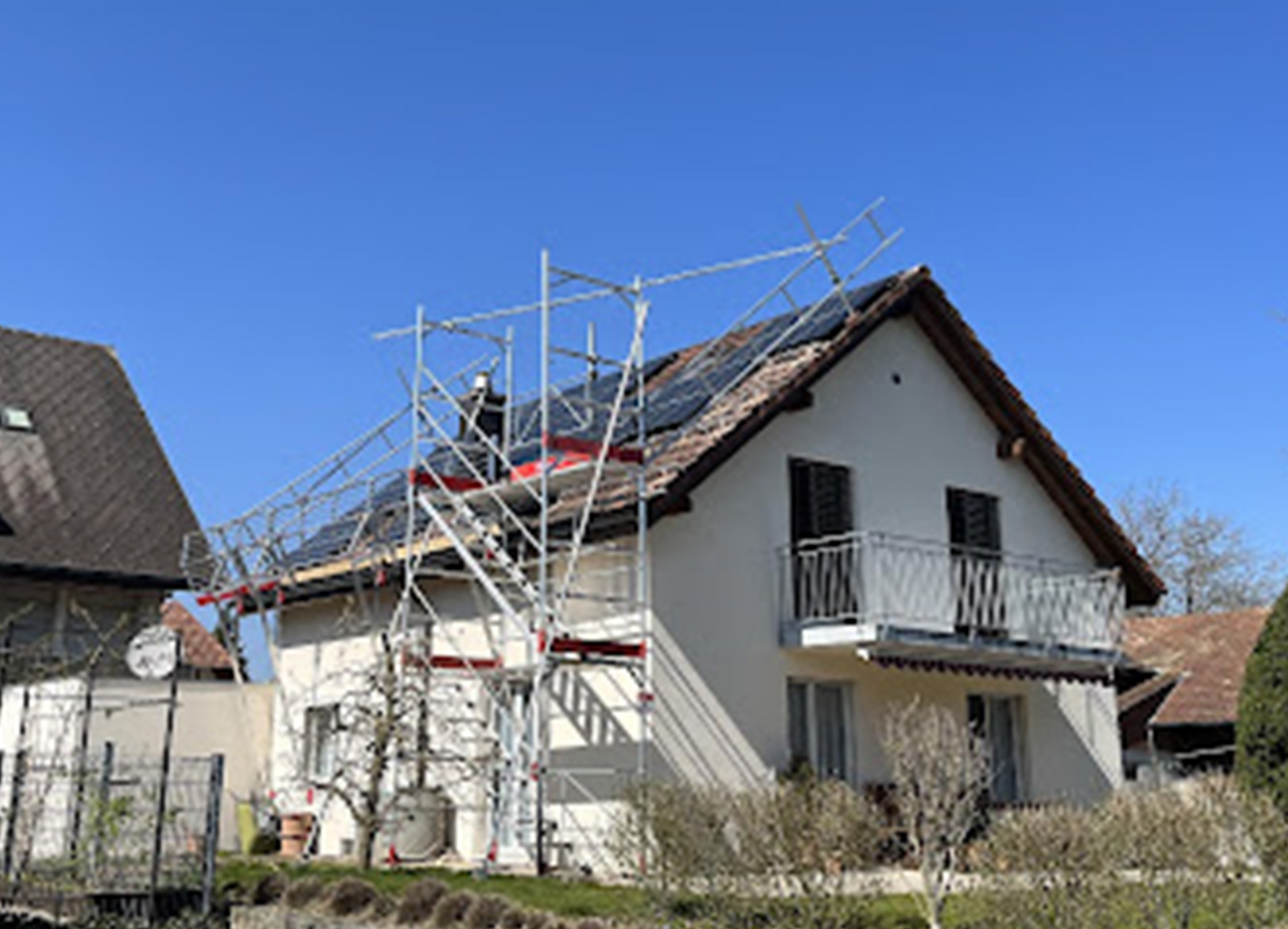 Eine Luftaufnahme eines Gebäudes mit Solarmodulen auf dem Dach.