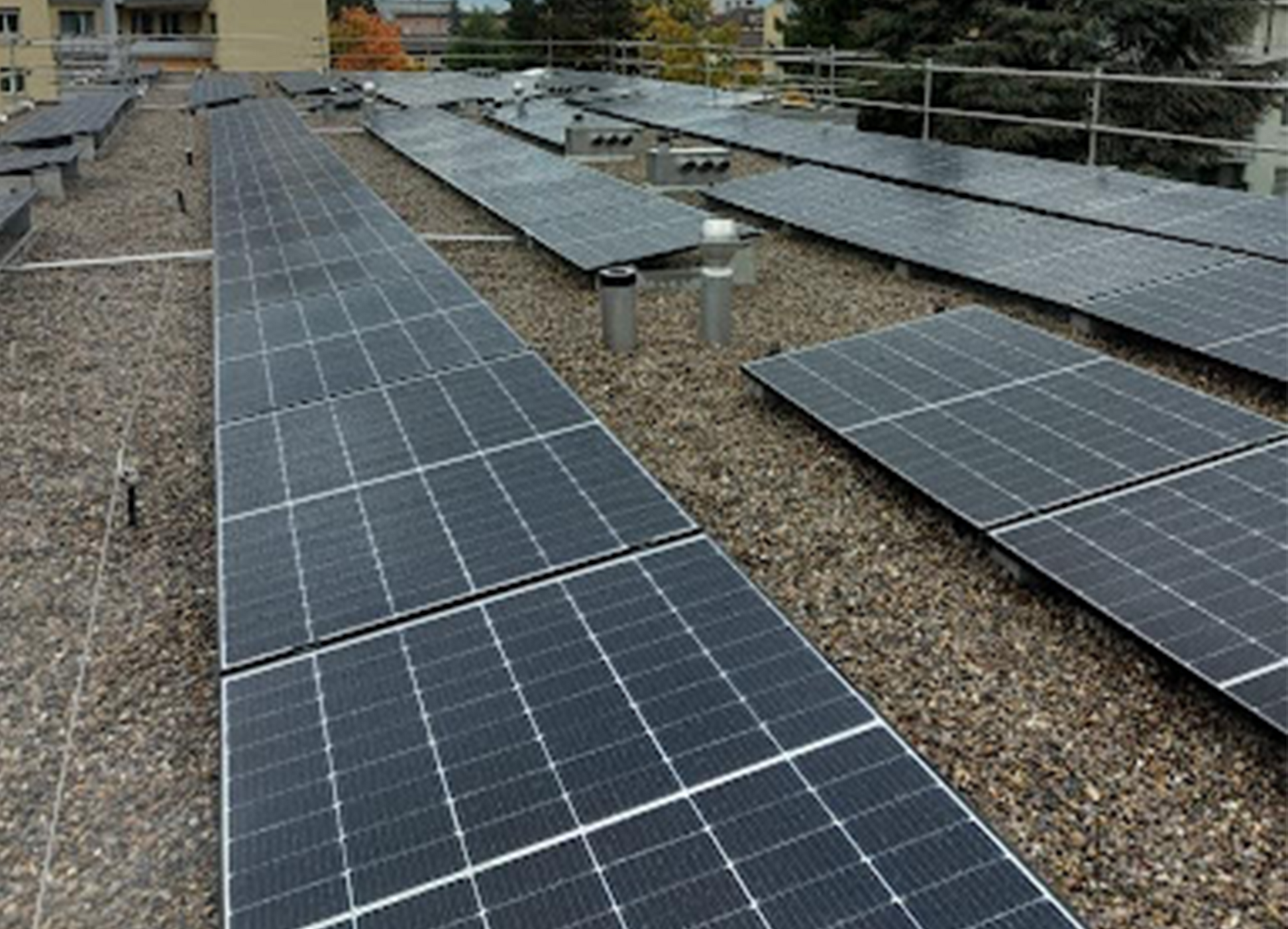 Eine Luftaufnahme eines Gebäudes mit Solarmodulen auf dem Dach.