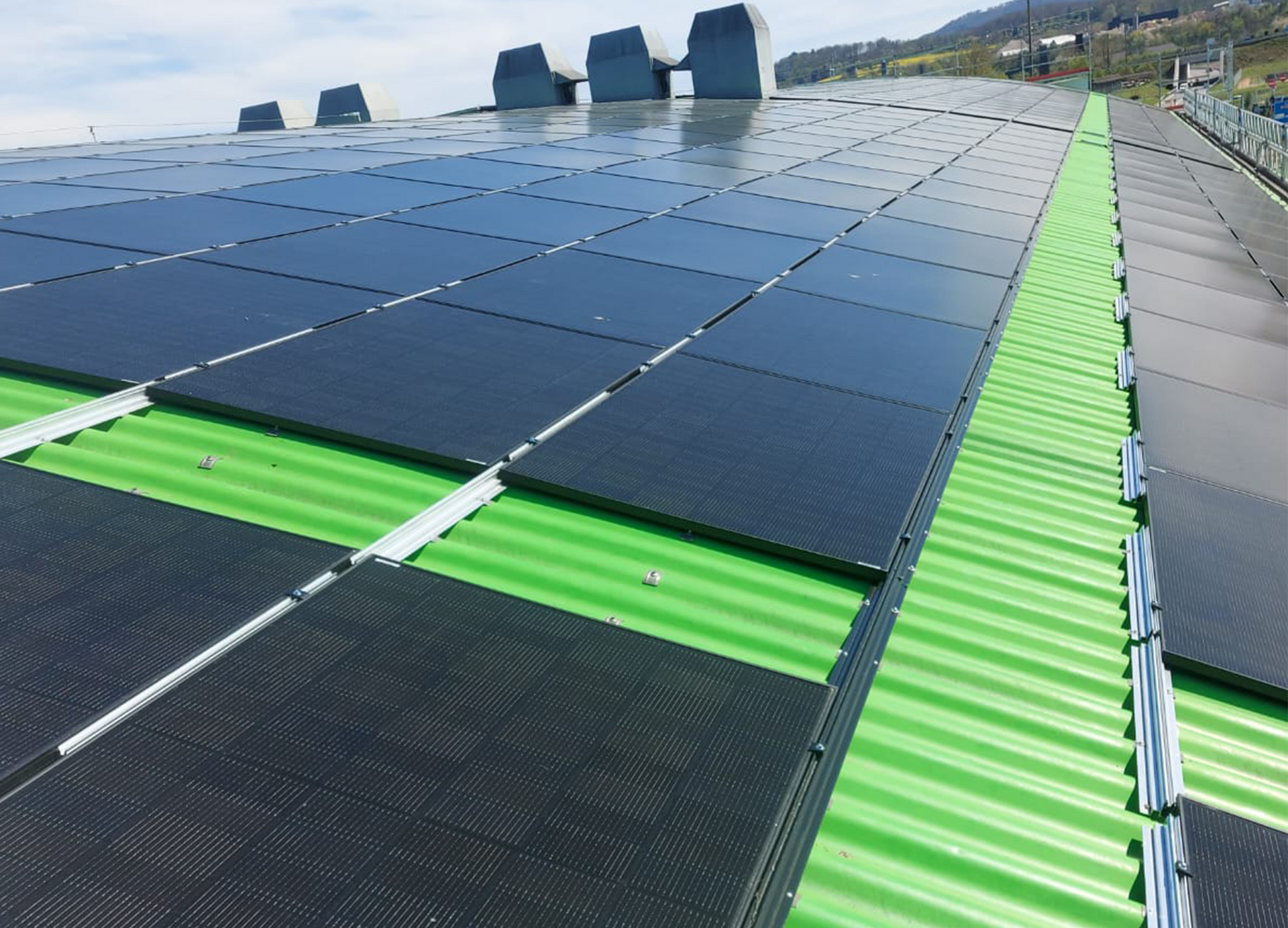 Eine Luftaufnahme eines Gebäudes mit Solarmodulen auf dem Dach