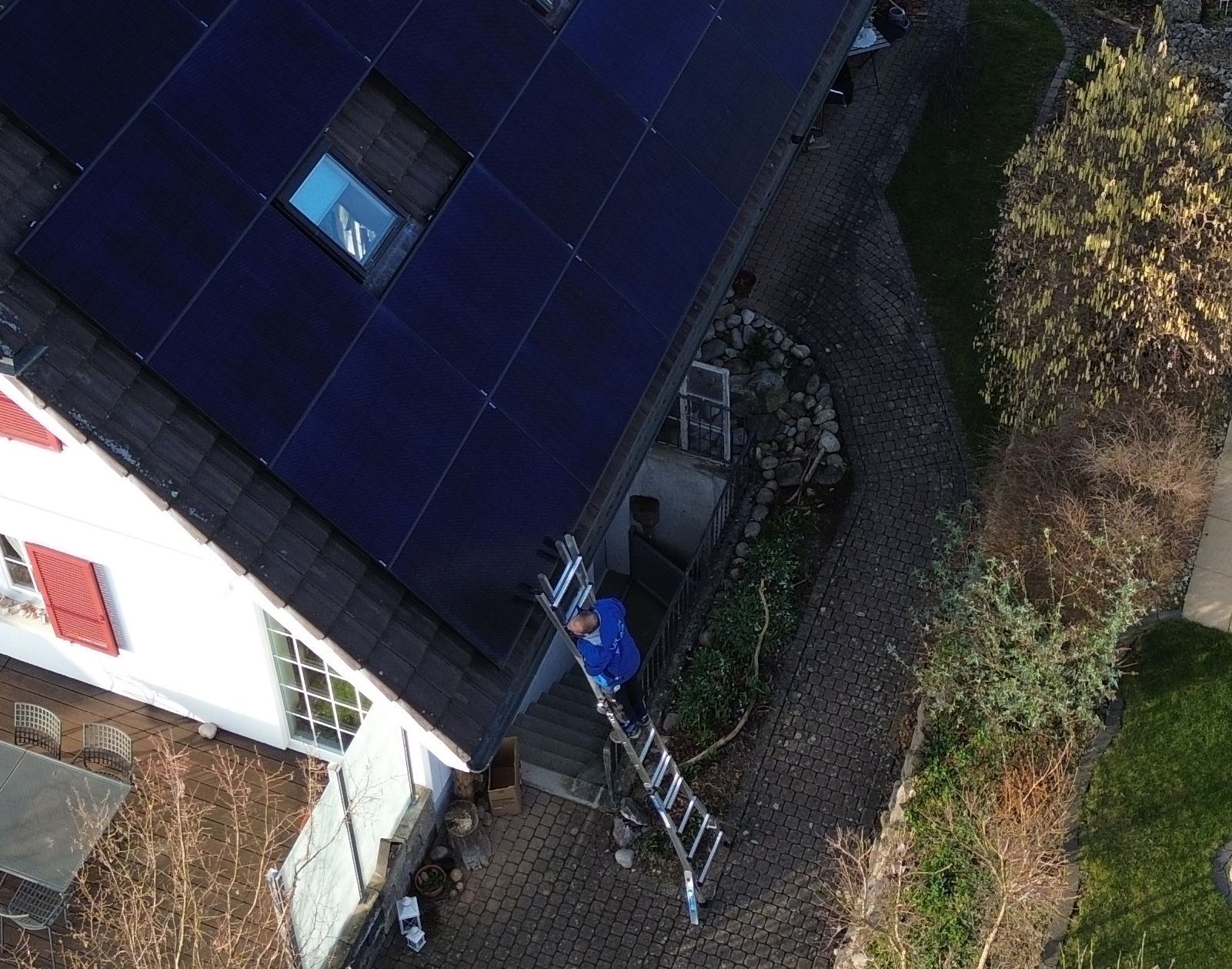 Eine Luftaufnahme eines Hauses mit Solarmodulen auf dem Dach