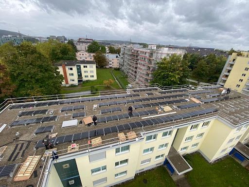 Eine Luftaufnahme eines Gebäudes mit Solarmodulen auf dem Dach.