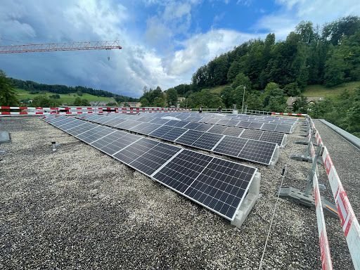 Eine Luftaufnahme eines Gebäudes mit Solarmodulen auf dem Dach.