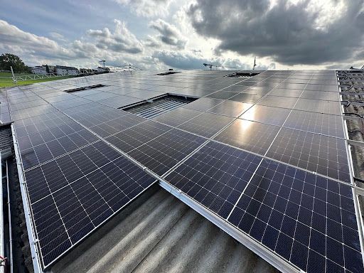 Eine Luftaufnahme eines Gebäudes mit Solarmodulen auf dem Dach.