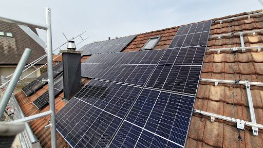 Eine Luftaufnahme eines Gebäudes mit Solarmodulen auf dem Dach.