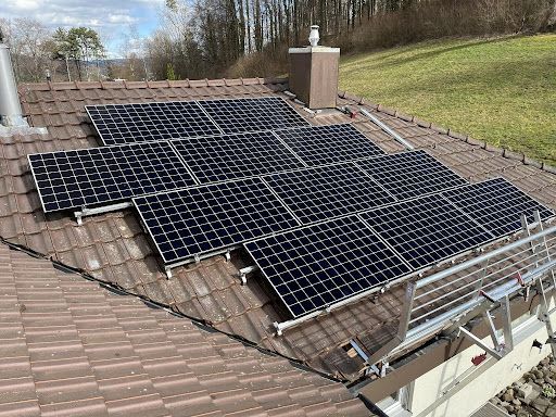 Eine Luftaufnahme eines Gebäudes mit Solarmodulen auf dem Dach.