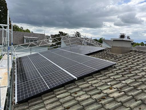 Eine Luftaufnahme eines Gebäudes mit Solarmodulen auf dem Dach.
