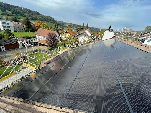 Eine Luftaufnahme eines Gebäudes mit Solarmodulen auf dem Dach.