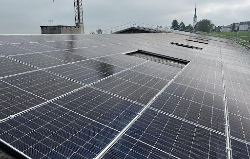 Eine Luftaufnahme eines Gebäudes mit Solarmodulen auf dem Dach