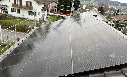 Solarmodule auf einem Ziegeldach montiert mit Metallschienen unter bewölktem Himmel installiert