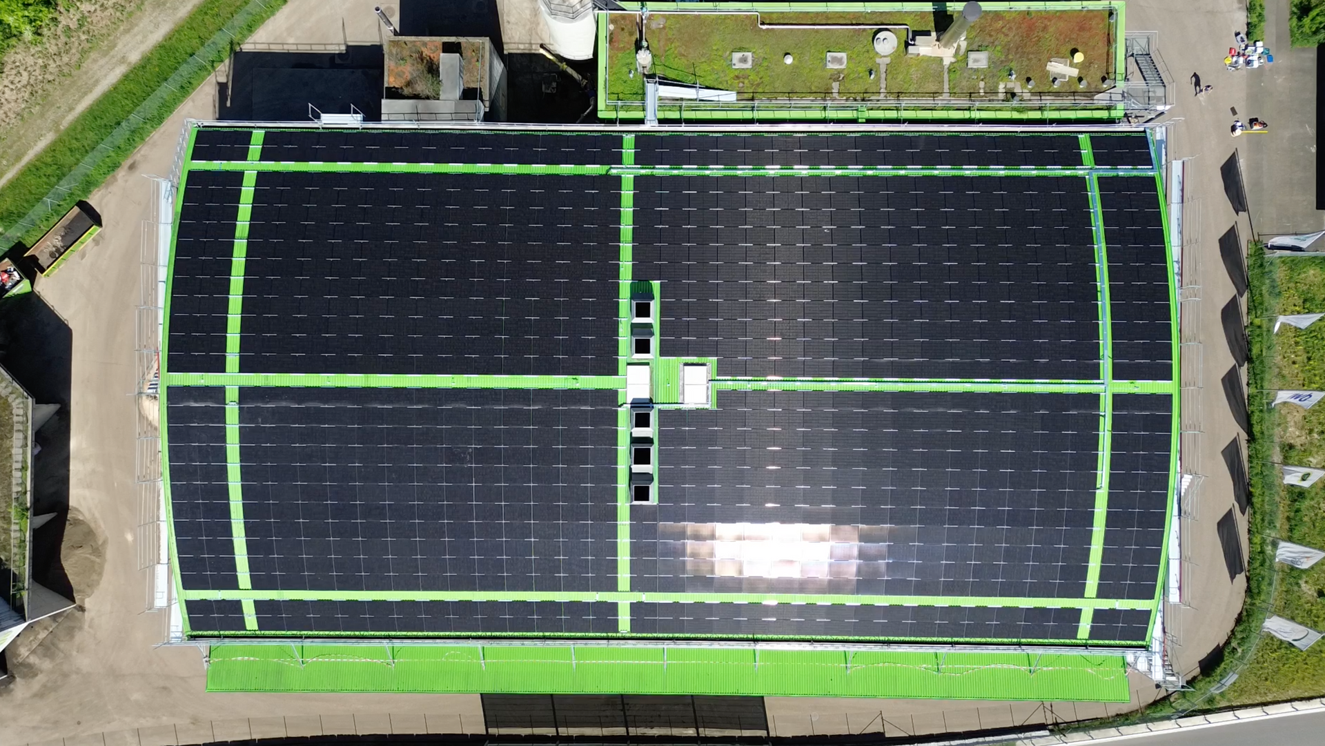 Eine Luftaufnahme eines Industriegebäude mit Solarmodulen auf dem Dach