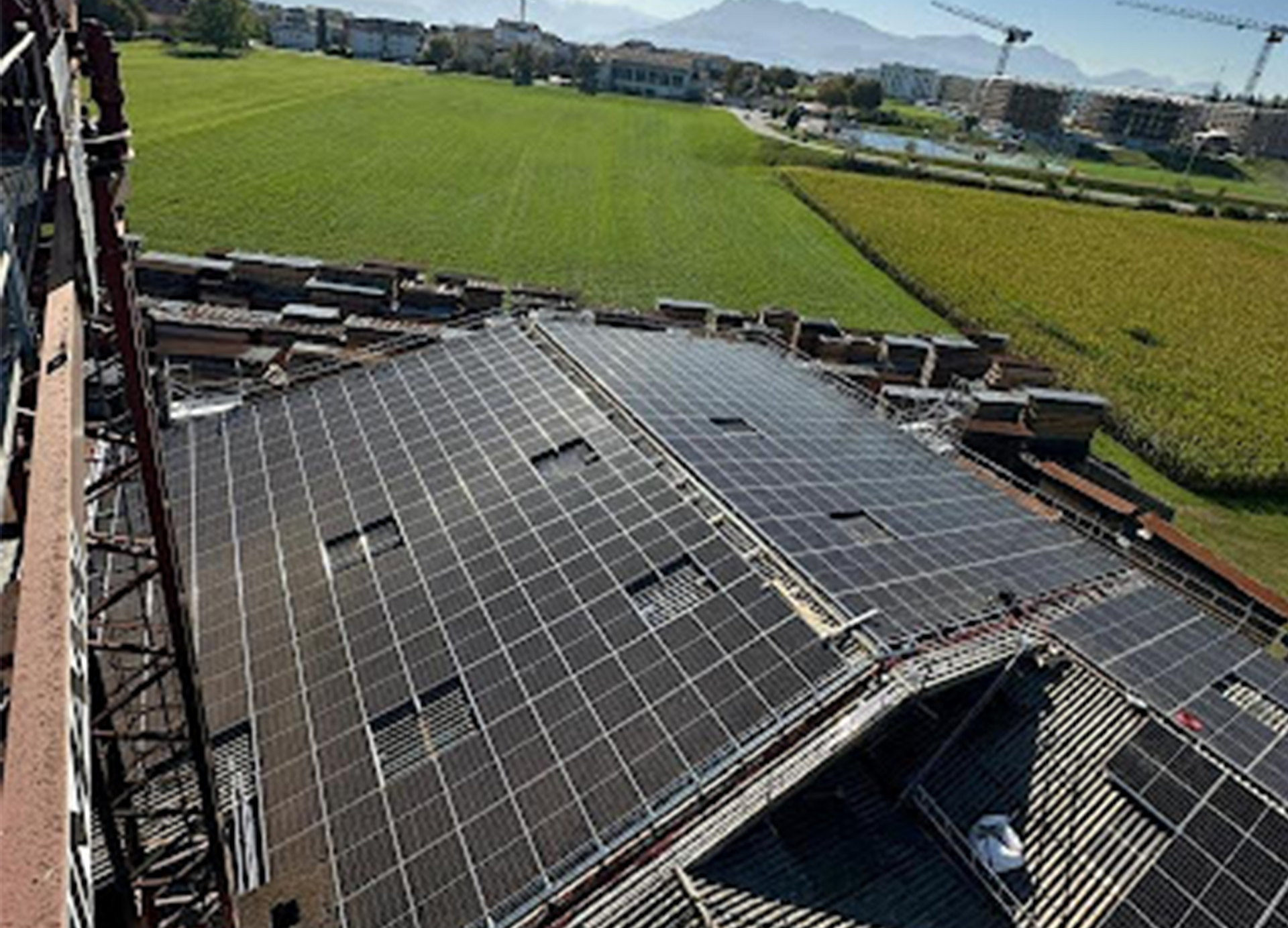 Eine Luftaufnahme eines Gebäudes mit Solarmodulen auf dem Dach