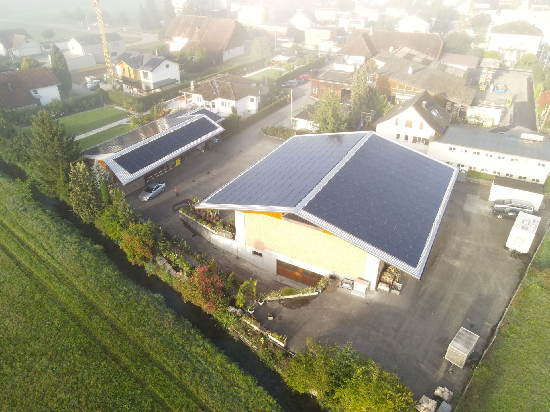 Eine Luftaufnahme eines Gebäudes mit Solarmodulen auf dem Dach