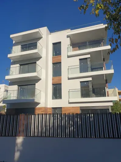 Un gran edificio de apartamentos con una valla delante.