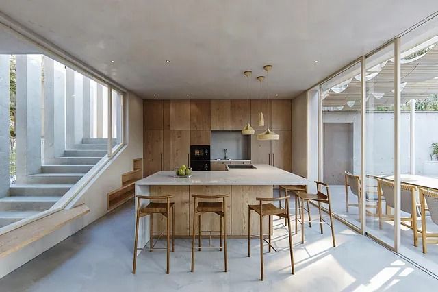 Una cocina con una gran isla y taburetes en ella.