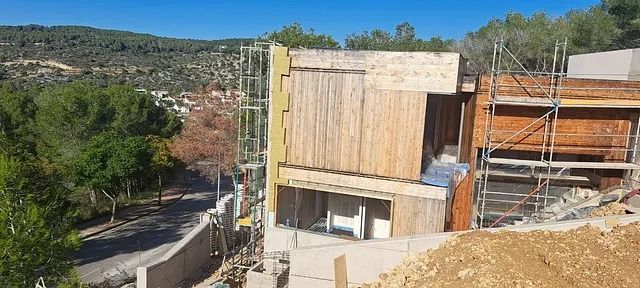 Se está construyendo una casa en una colina con andamios a su alrededor.