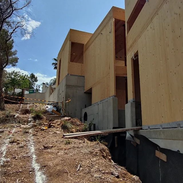 Se está construyendo un gran edificio de madera en una ladera.