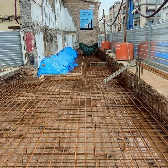 Un edificio en construcción con una lona azul en el suelo.