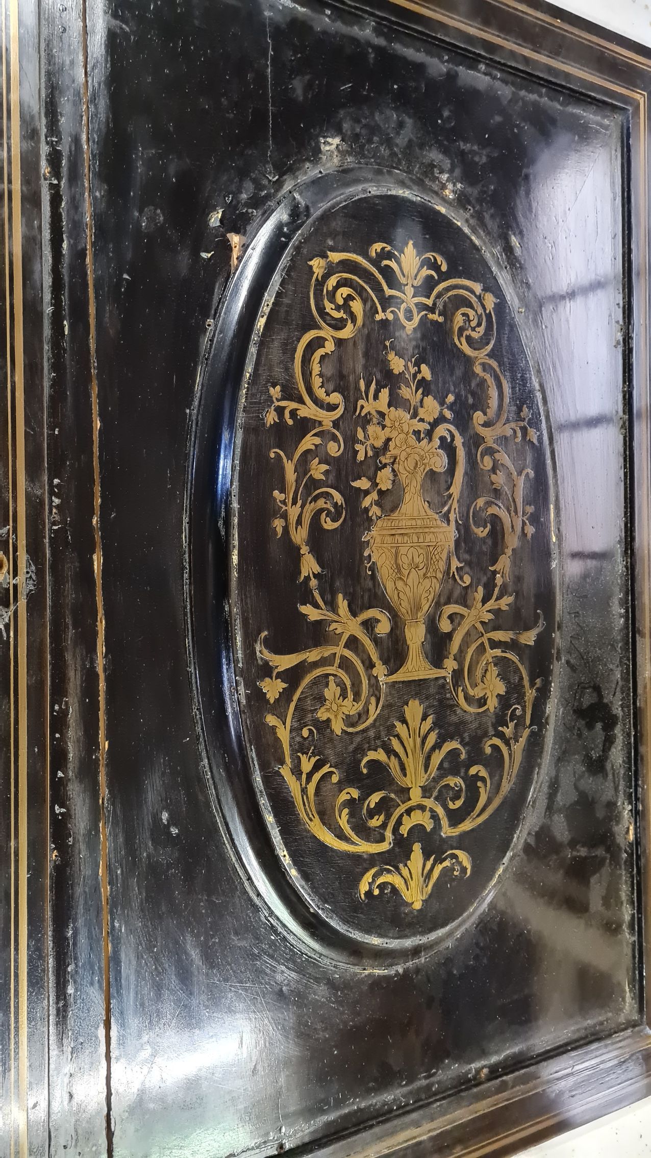 Porte d'un meuble ancien en bois noir et dorure