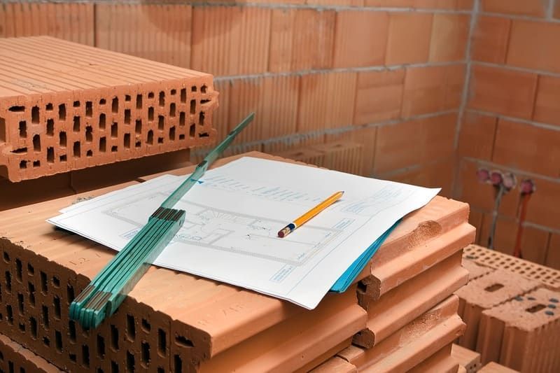 ein Stapel Ziegel mit einem Bleistift und einem Lineal darauf