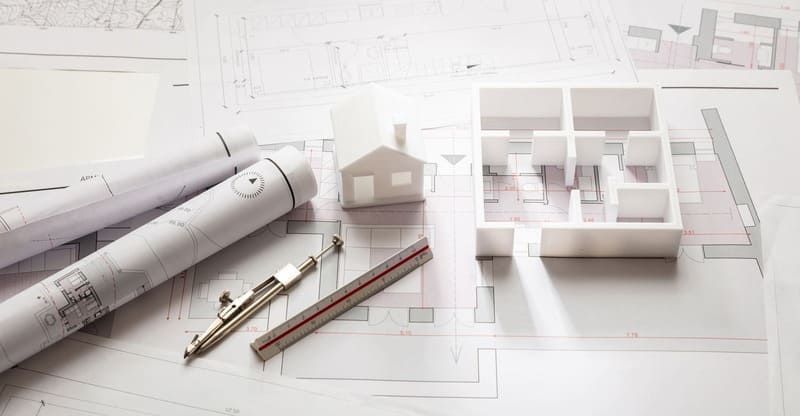 Ein Modell eines Hauses sitzt auf einem Tisch neben einem Lineal und einem Kompass | Ingenieurbüro B. Eng. D. Blattner